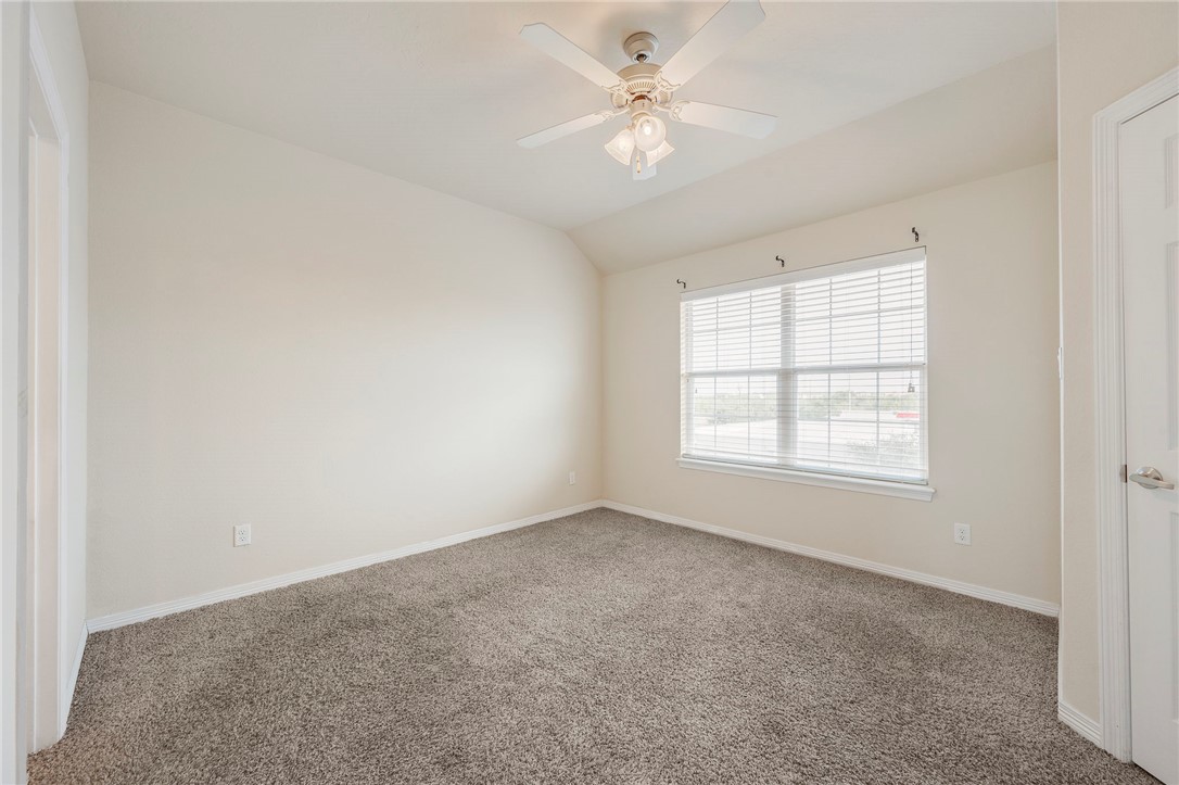 1198 Jones-Butler Road, Unit 2108 College Station, TX 77840 - Photo 7 of 10 an empty room with chandelier fan and windows