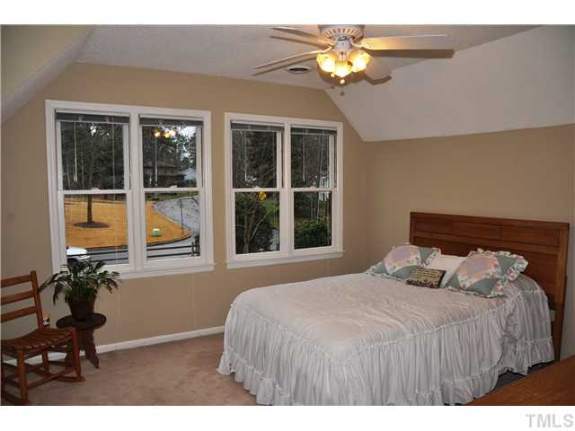 7528 Fiesta Way Raleigh, NC 27615 - Photo 15 of 22 a bedroom with a bed mirror and a window