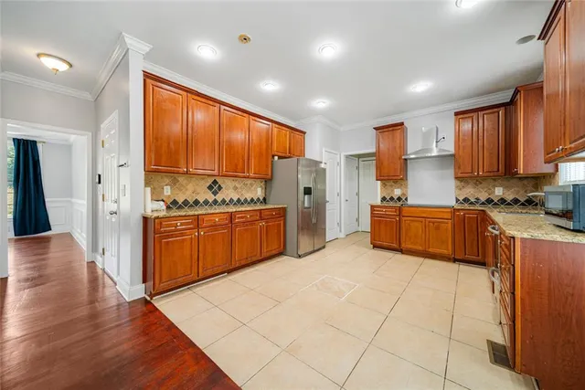 a kitchen with stainless steel appliances granite countertop a refrigerator and a stove top oven