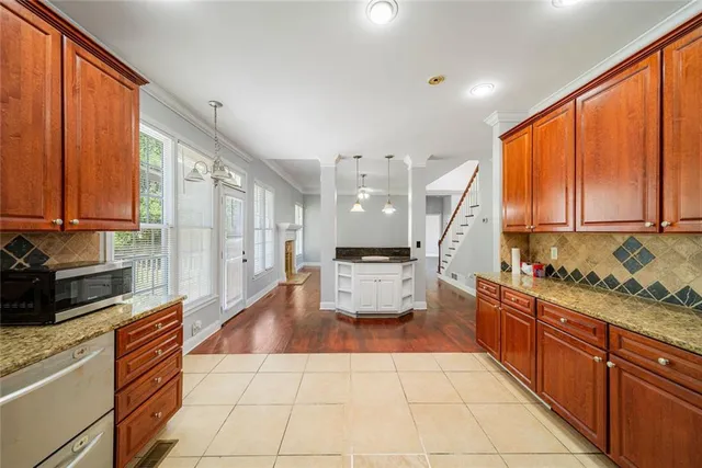 a kitchen with stainless steel appliances kitchen island granite countertop a refrigerator a sink dishwasher stove with open cabinets