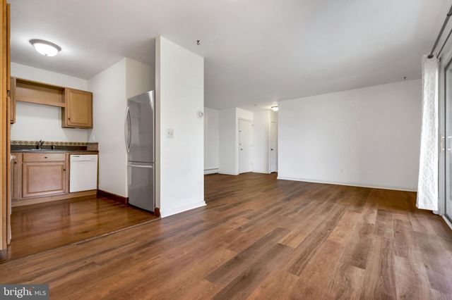 a view of a kitchen with wooden floor and a sink