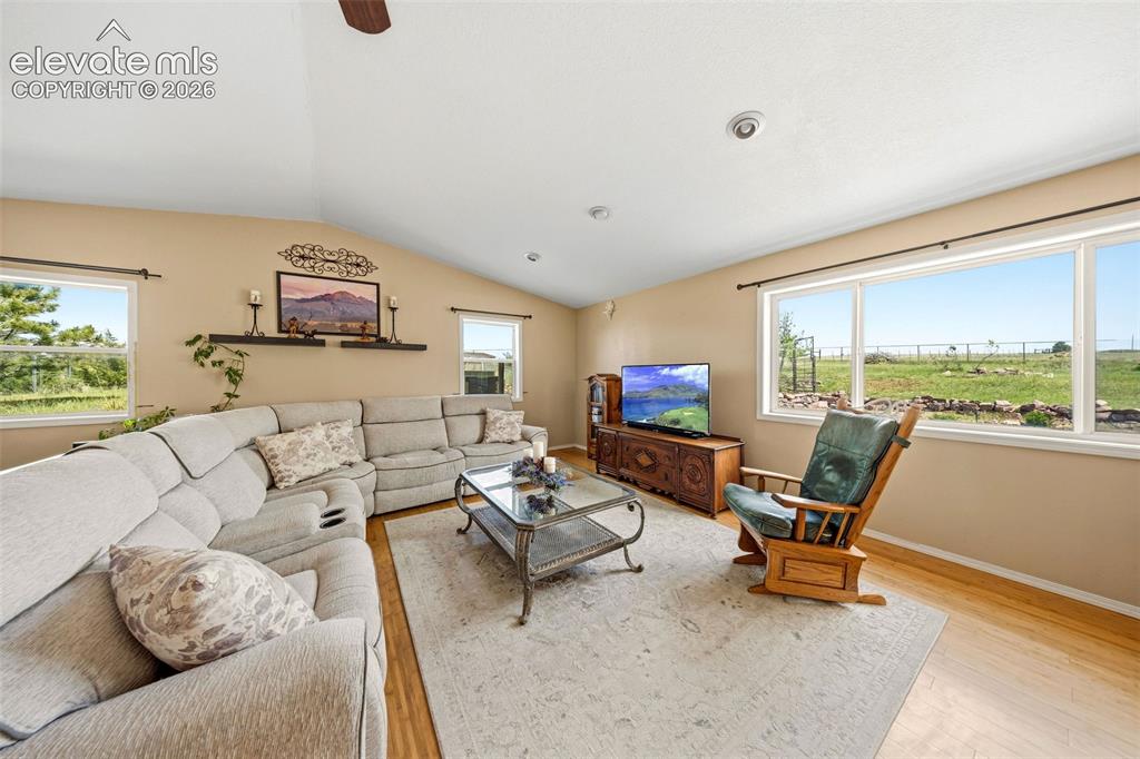 13075 Blaney Road South Peyton, CO 80831 - Photo 13 of 40 Spacious living area featuring a vaulted ceiling and wood-finish flooring