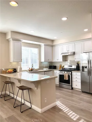 a kitchen with kitchen island granite countertop wooden cabinets and stainless steel appliances
