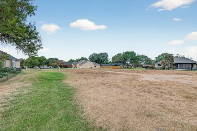 a backyard of a house with lots of green space and trees
