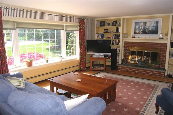 25 Jeffrey Road Wayland, MA 01778 - Photo 5 of 16 a living room with furniture a flat screen tv and a fireplace