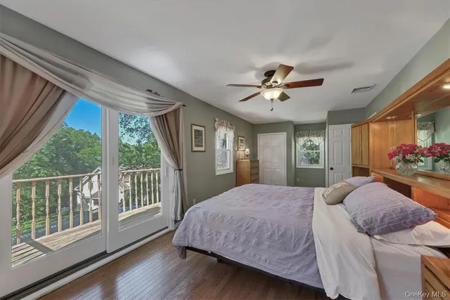a bedroom with a bed and a large window with wooden floor