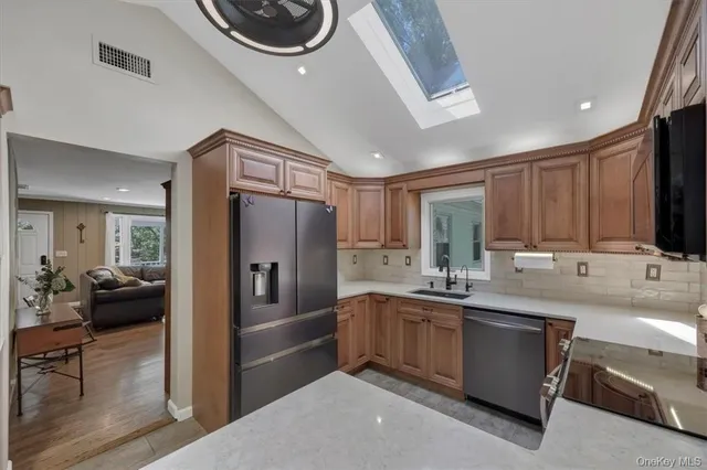 a kitchen with stainless steel appliances granite countertop a sink stove and refrigerator