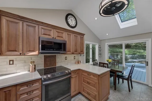 a kitchen with stainless steel appliances granite countertop a stove a microwave and a sink