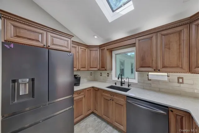 a kitchen with stainless steel appliances granite countertop a sink refrigerator and cabinets