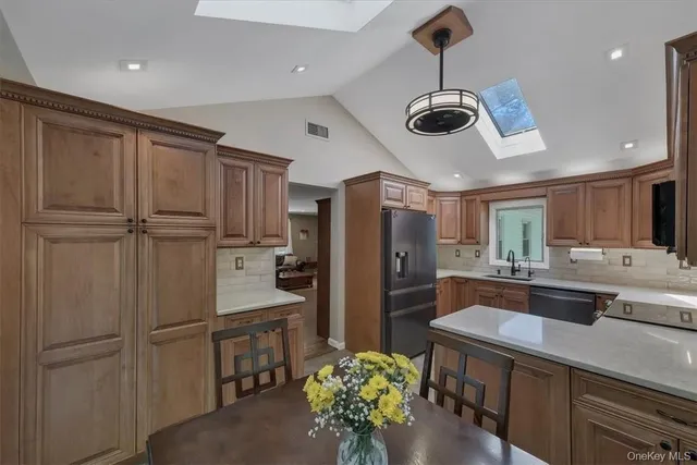 a kitchen with kitchen island a counter top space stainless steel appliances and cabinets