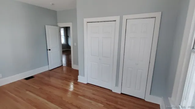 a view of an empty room with wooden floor