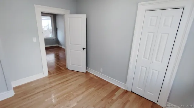 an empty room with wooden floor and closet