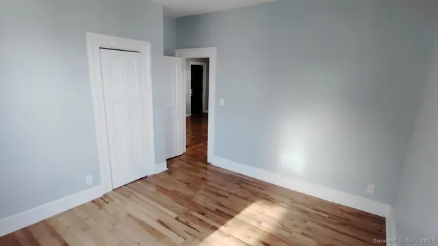 a view of an empty room with wooden floor