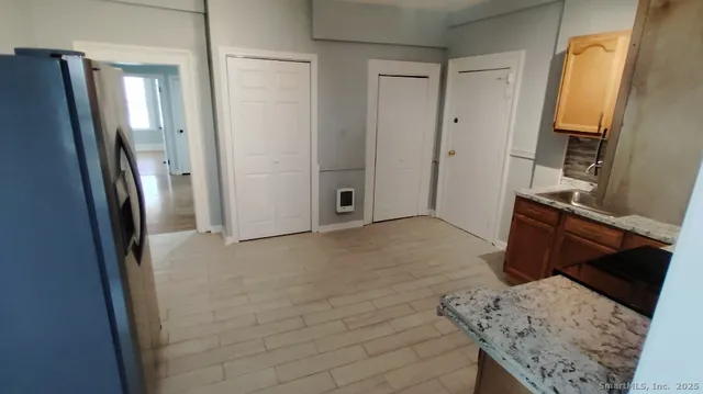 a view of hallway with furniture and a refrigerator