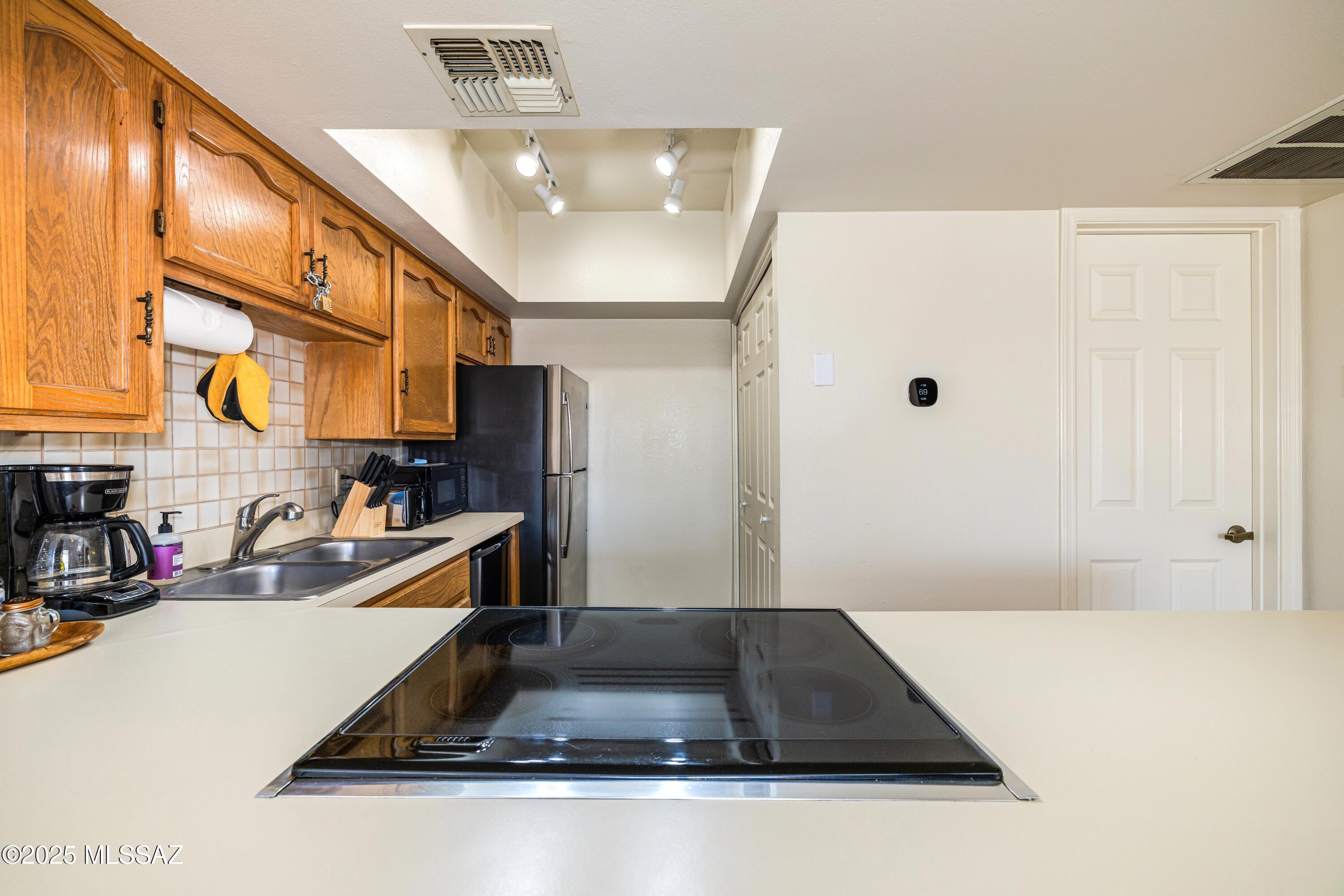 1200 East River Road, Unit G88 Tucson, AZ 85718 - Photo 3 of 13 a kitchen with a sink and a refrigerator