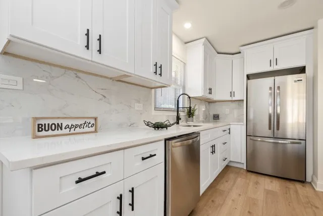a kitchen with stainless steel appliances a refrigerator sink and cabinets