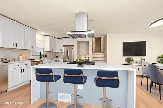 a kitchen with stainless steel appliances a stove top oven cabinets and a refrigerator
