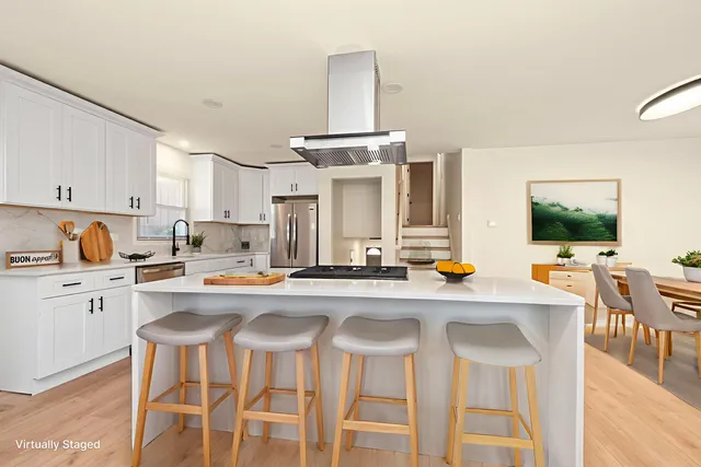 a kitchen with stainless steel appliances a stove a table and chairs