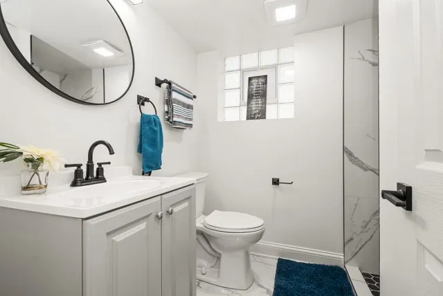 a bathroom with a sink toilet and a mirror