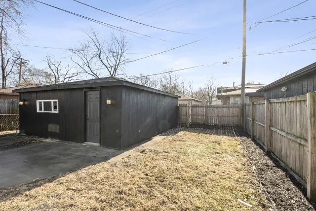 a backyard of a house with dining table and chairs