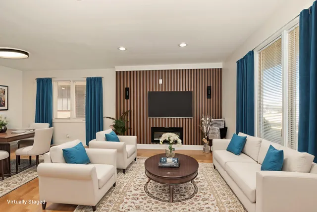 a living room with furniture a rug a lamp and a large window