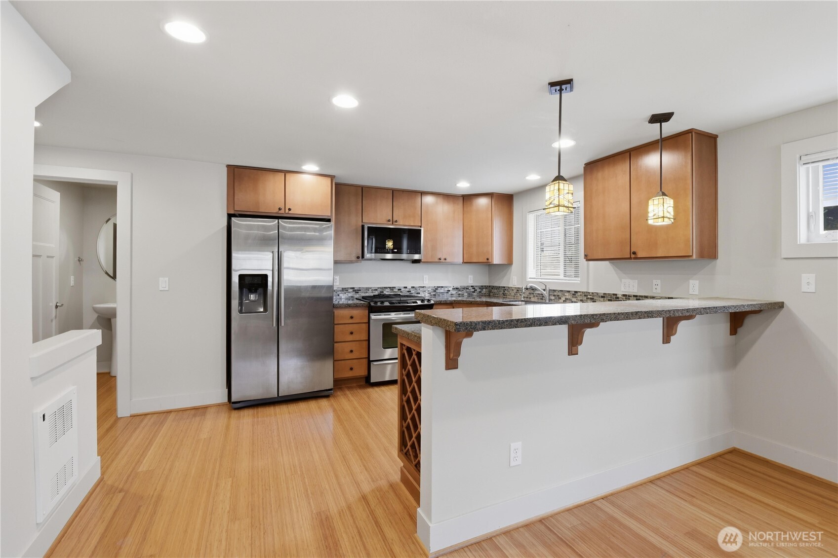 723 North 95th Street, Unit A Seattle, WA 98103 - Photo 5 of 20 a kitchen with stainless steel appliances granite countertop a refrigerator a sink a stove and a wooden floors