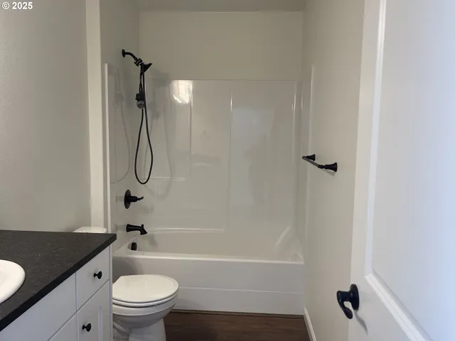 a bathroom with a granite countertop toilet sink and shower