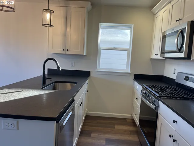 a kitchen with stainless steel appliances granite countertop a sink stove and refrigerator