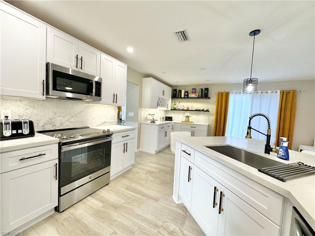 3639 Kent Drive Naples, FL 34112 - Photo 16 of 40 a kitchen with granite countertop a sink stainless steel appliances and cabinets