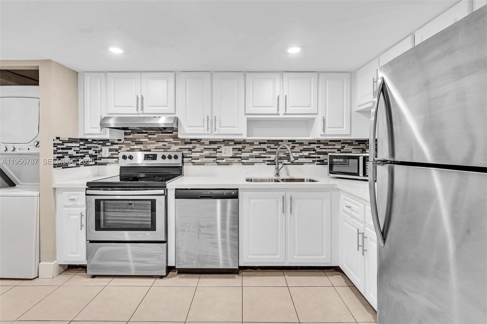 400 Commodore Drive, Unit 215 Plantation, FL 33325 - Photo 8 of 30 a kitchen with stainless steel appliances granite countertop a stove a refrigerator and a refrigerator