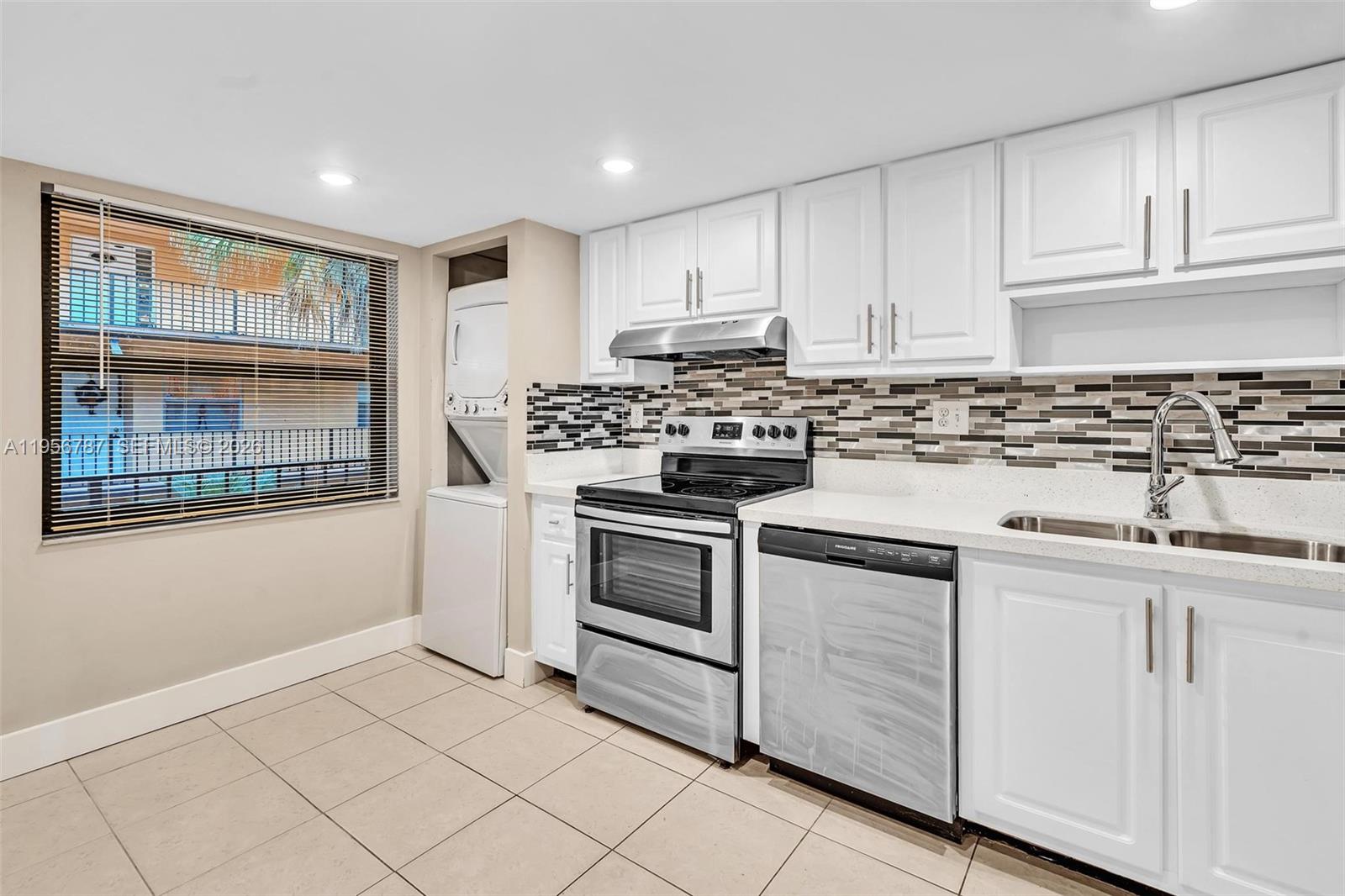 400 Commodore Drive, Unit 215 Plantation, FL 33325 - Photo 9 of 30 a kitchen with white cabinets and appliances