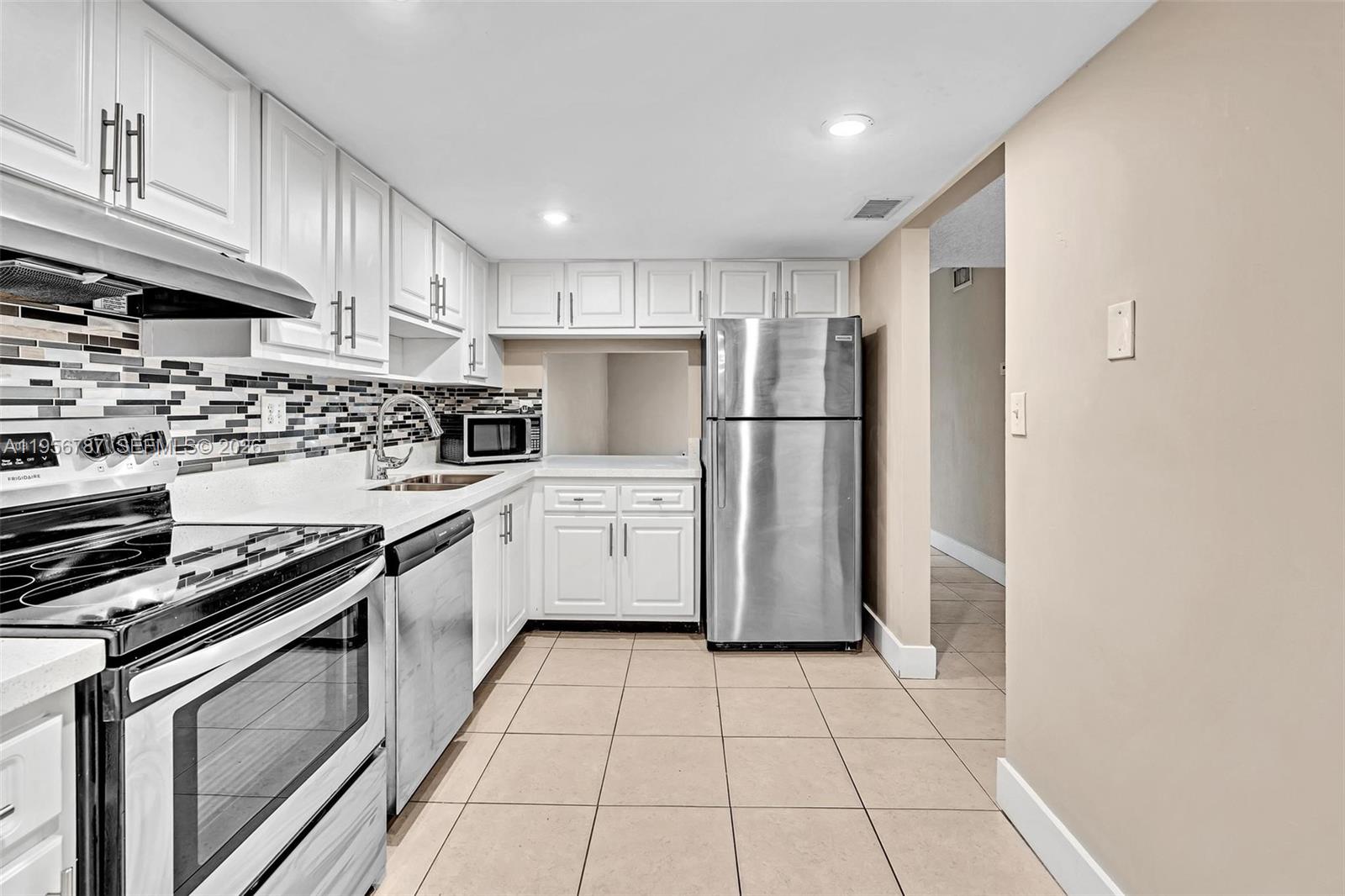 400 Commodore Drive, Unit 215 Plantation, FL 33325 - Photo 10 of 30 a kitchen with white cabinets and appliances
