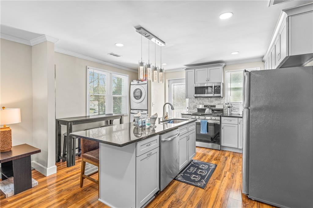1298 Douglas Street Southwest, Unit A Atlanta, GA 30314 - Photo 4 of 11 a kitchen with stainless steel appliances granite countertop a sink stove and refrigerator