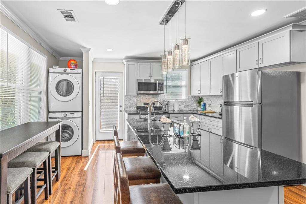 1298 Douglas Street Southwest, Unit A Atlanta, GA 30314 - Photo 5 of 11 a kitchen with stainless steel appliances granite countertop a refrigerator a stove and a sink with wooden floor