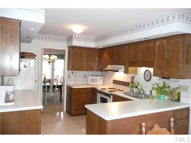 8312 North Creek Run Raleigh, NC 27613 - Photo 10 of 17 a kitchen with a sink a stove and chairs