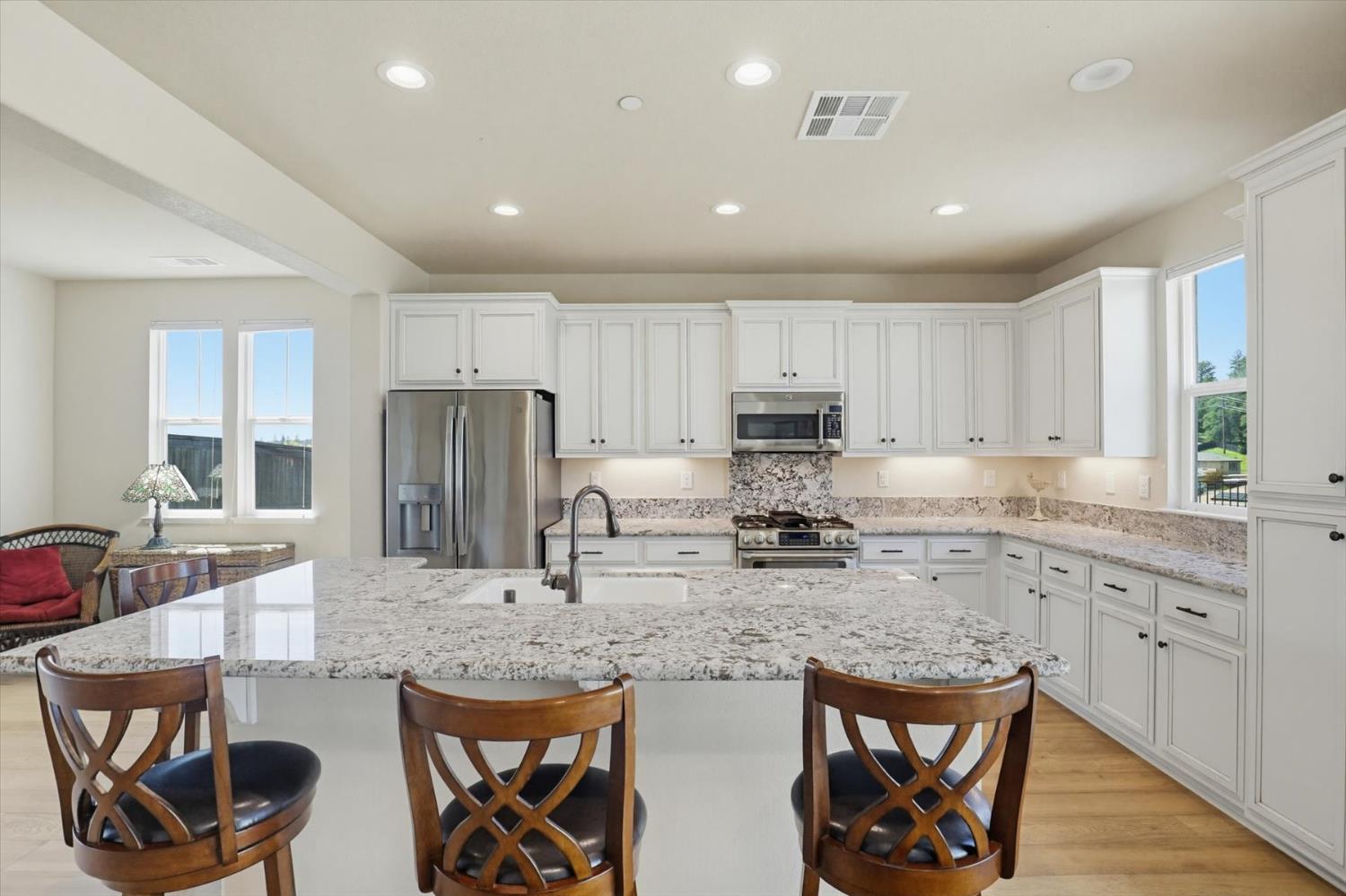 21456 Rucker Court Grass Valley, CA 95949 - Photo 15 of 74 a kitchen with stainless steel appliances granite countertop a stove a sink a refrigerator a dining table and chairs