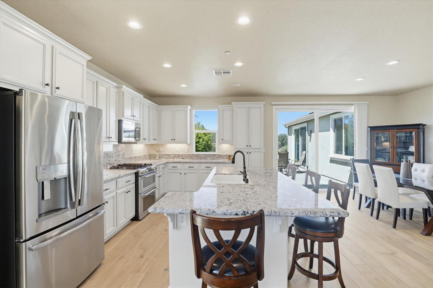 21456 Rucker Court Grass Valley, CA 95949 - Photo 16 of 74 a kitchen with stainless steel appliances granite countertop a table chairs refrigerator and a sink