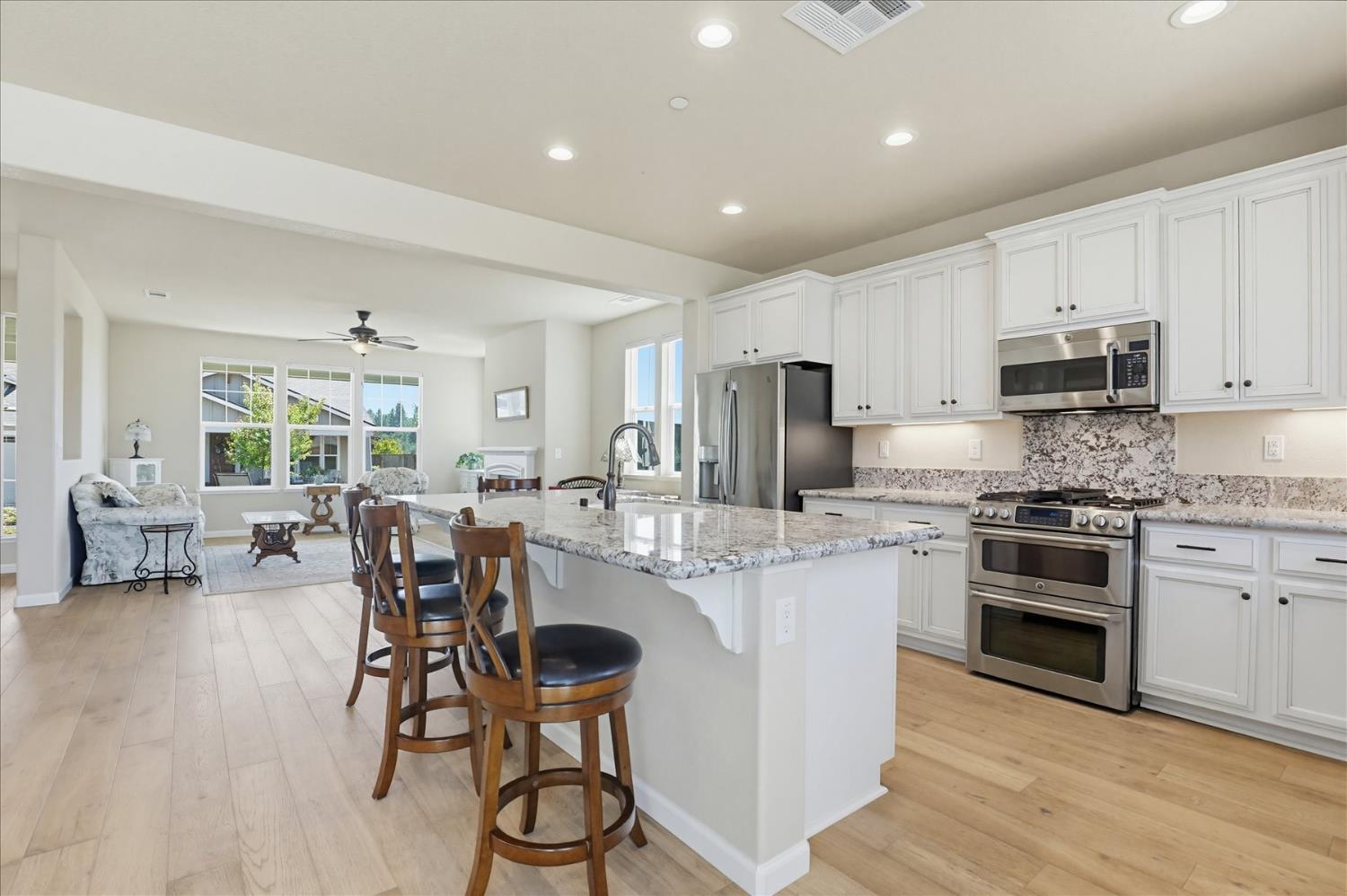 21456 Rucker Court Grass Valley, CA 95949 - Photo 17 of 74 a kitchen with stainless steel appliances granite countertop a stove top oven a sink dishwasher a dining table and chairs with wooden floor