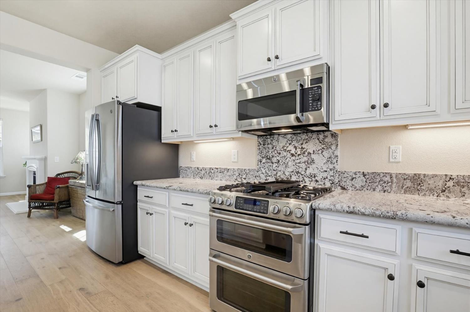 21456 Rucker Court Grass Valley, CA 95949 - Photo 18 of 74 a kitchen with white cabinets and stainless steel appliances