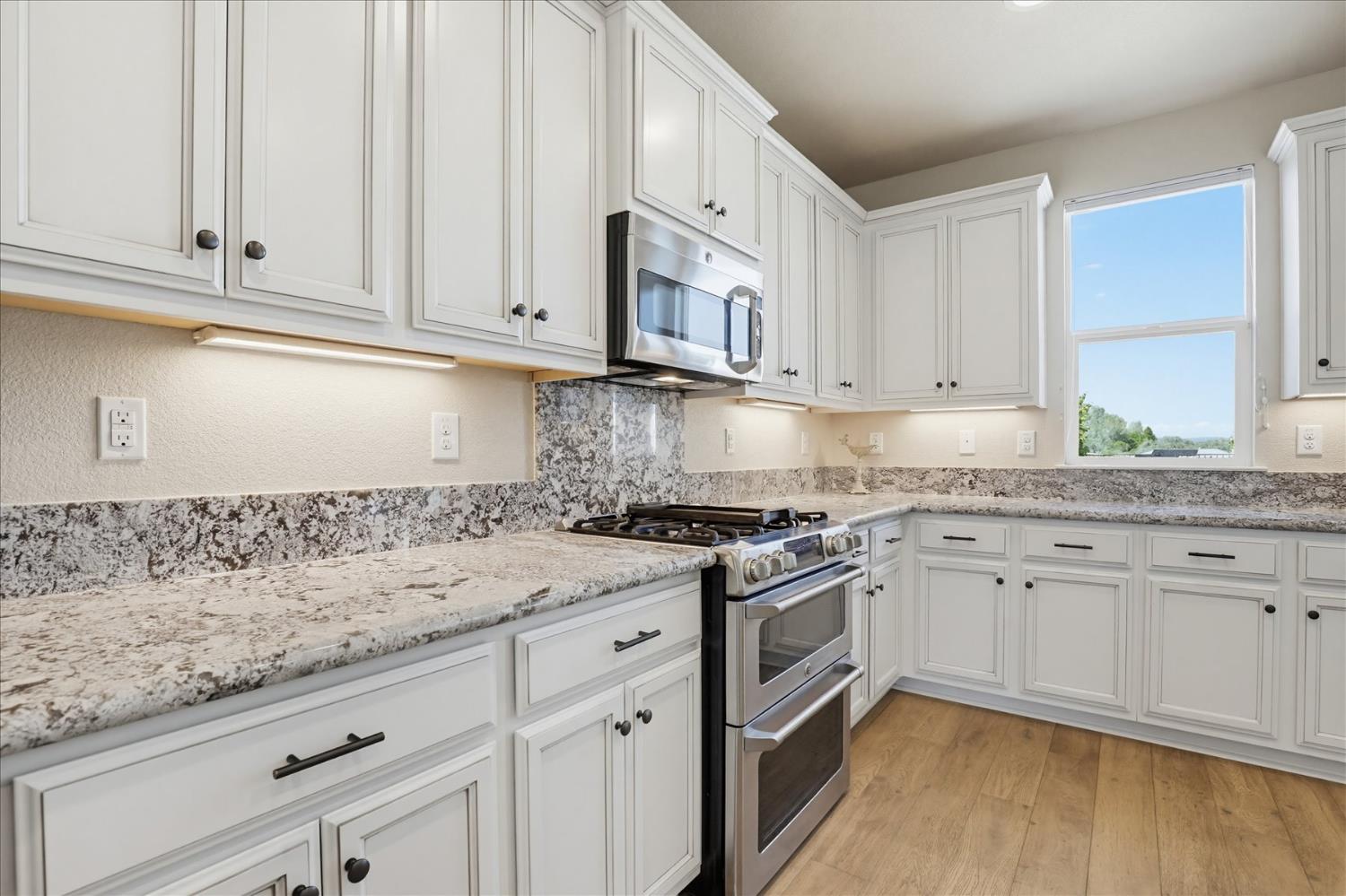 21456 Rucker Court Grass Valley, CA 95949 - Photo 22 of 74 a kitchen with granite countertop white cabinets and a stove