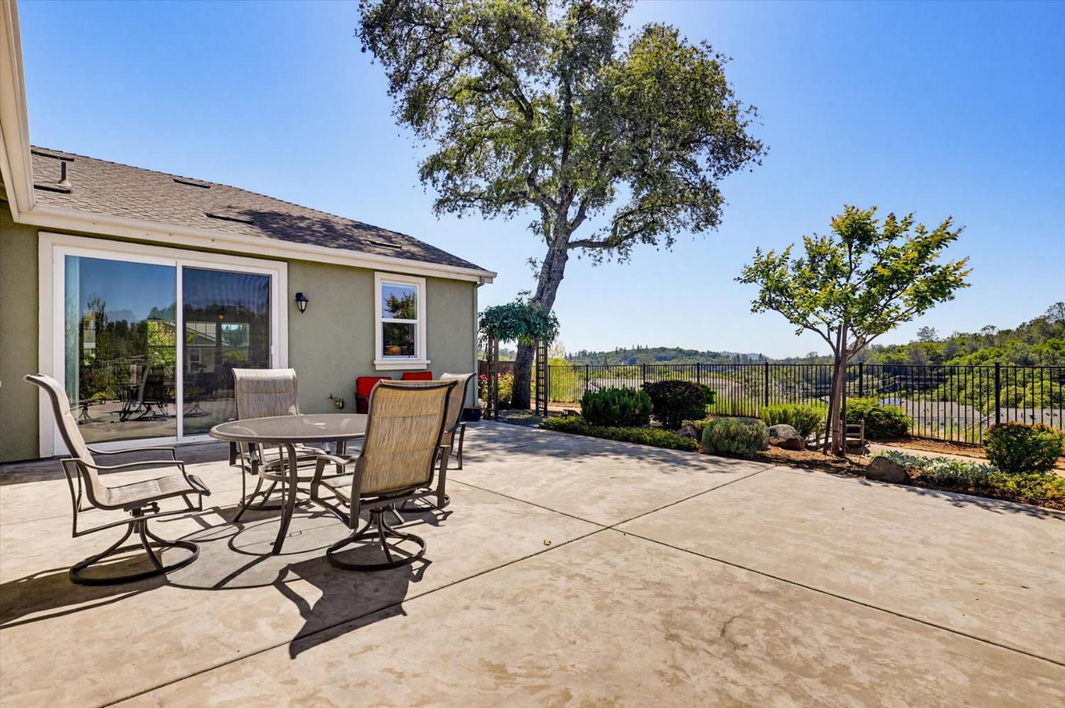 21456 Rucker Court Grass Valley, CA 95949 - Photo 55 of 74 a view of a patio with couches table and chairs under an umbrella with palm trees