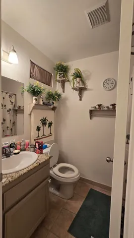 a bathroom with a granite countertop sink and a toilet