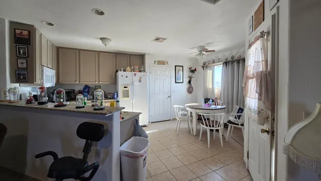a kitchen with refrigerator and chairs