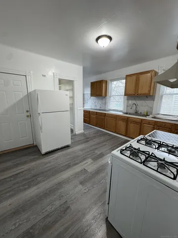 a kitchen with granite countertop a stove a sink and a microwave