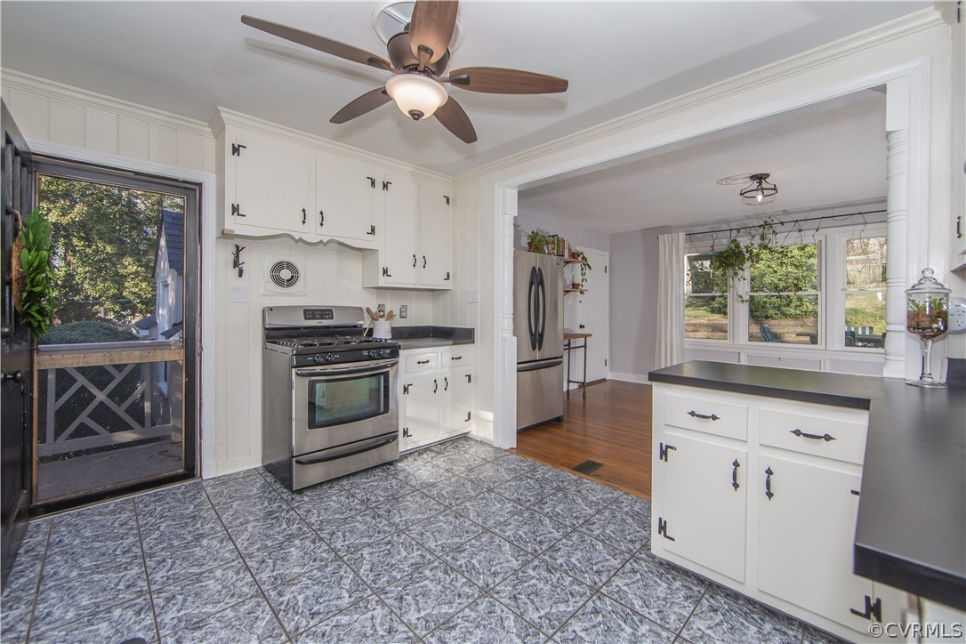 3921 Wakefield Road Richmond, VA 23235 - Photo 14 of 50 a kitchen with stainless steel appliances a stove a refrigerator cabinets and a window