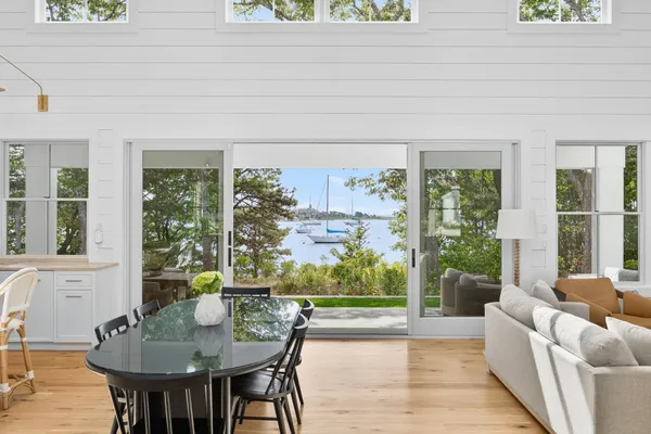 a kitchen with stainless steel appliances granite countertop a stove a sink dishwasher and a dining table with wooden floor