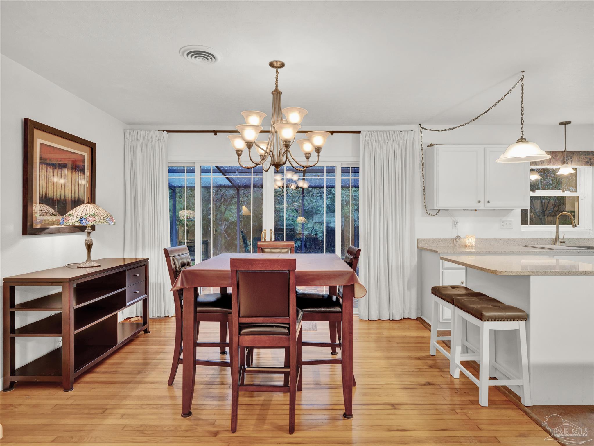 111 Euclid Road Pensacola, FL 32503 - Photo 17 of 34 a dining room with wooden floor a chandelier a wooden table and chairs