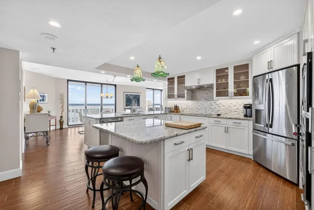 a kitchen with stainless steel appliances granite countertop a refrigerator and a stove top oven