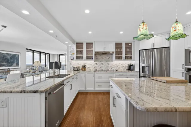 a large kitchen with kitchen island a large counter top stainless steel appliances and cabinets
