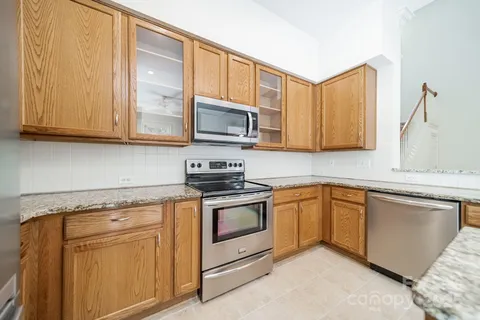 a kitchen with granite countertop cabinets stainless steel appliances and a sink